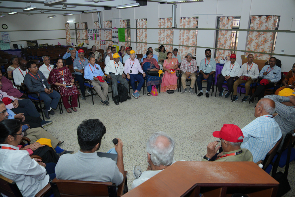 HTBF dignitaries sit at tables, writing notes while listening to a session during the Annual Meet.